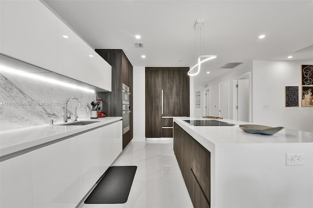 kitchen featuring black electric cooktop, a center island, sink, and white cabinets