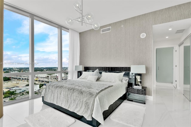 bedroom featuring a notable chandelier and floor to ceiling windows