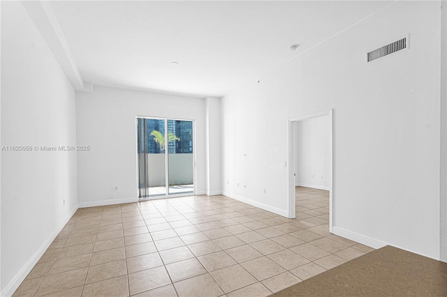 spare room featuring light tile patterned floors, baseboards, and visible vents