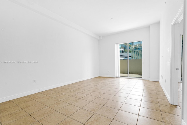 spare room featuring baseboards and light tile patterned floors