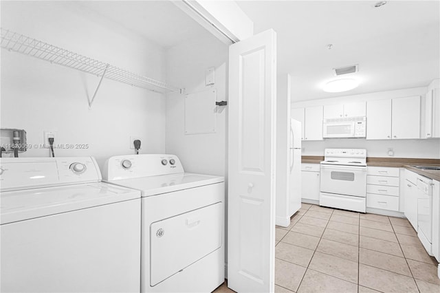 laundry room featuring light tile patterned flooring, laundry area, separate washer and dryer, a sink, and visible vents