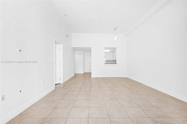 unfurnished room featuring light tile patterned floors and baseboards