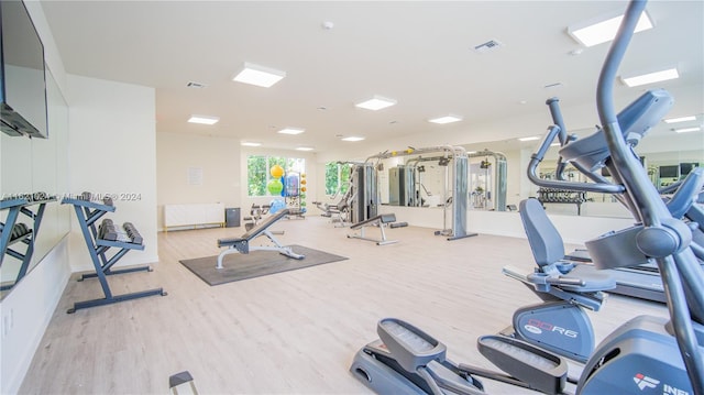 exercise room with light hardwood / wood-style flooring