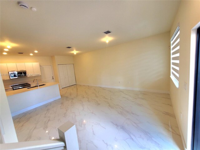 interior space with sink and white cabinets