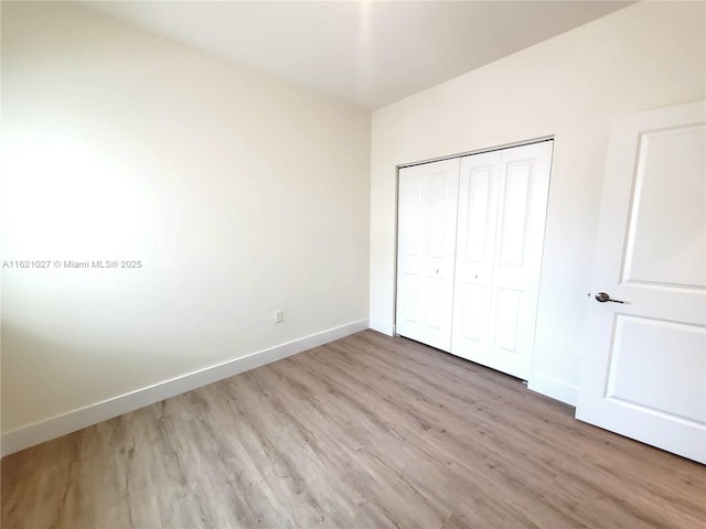 unfurnished bedroom with light hardwood / wood-style floors and a closet