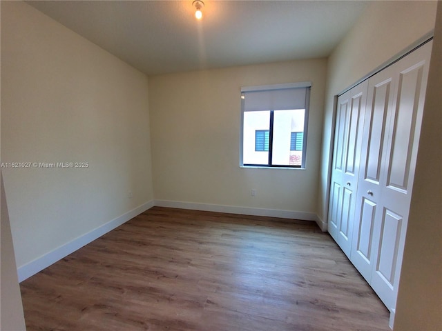 unfurnished bedroom with a closet and light hardwood / wood-style flooring