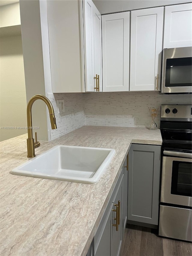 kitchen featuring sink, decorative backsplash, dark hardwood / wood-style floors, and stainless steel appliances