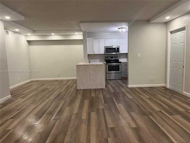 kitchen featuring appliances with stainless steel finishes, sink, tasteful backsplash, and dark hardwood / wood-style floors