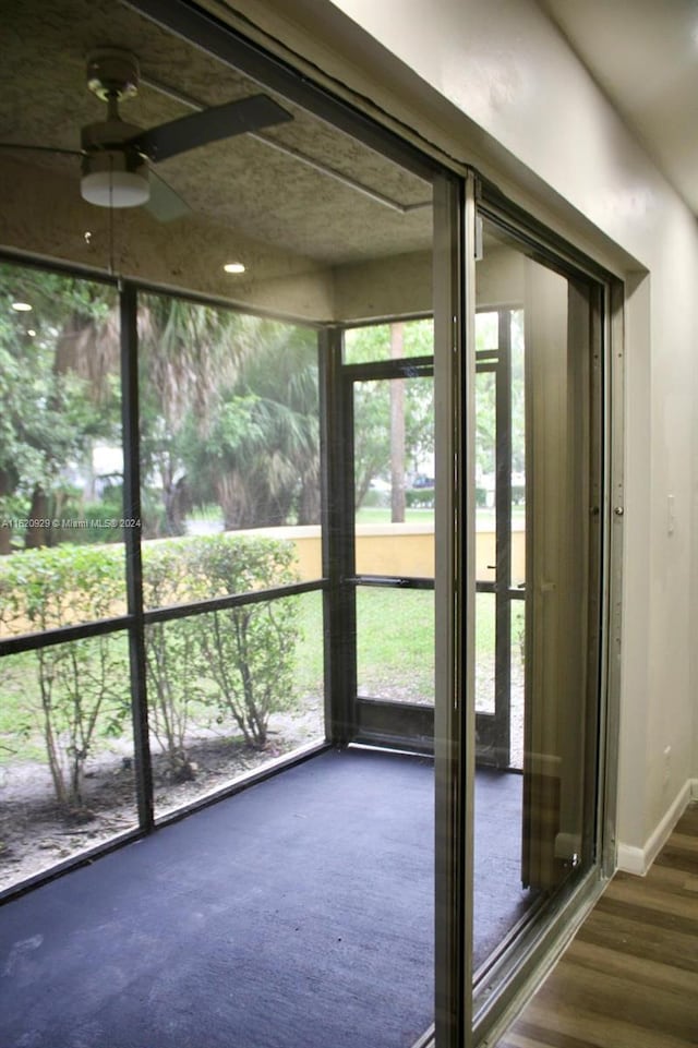 unfurnished sunroom with ceiling fan