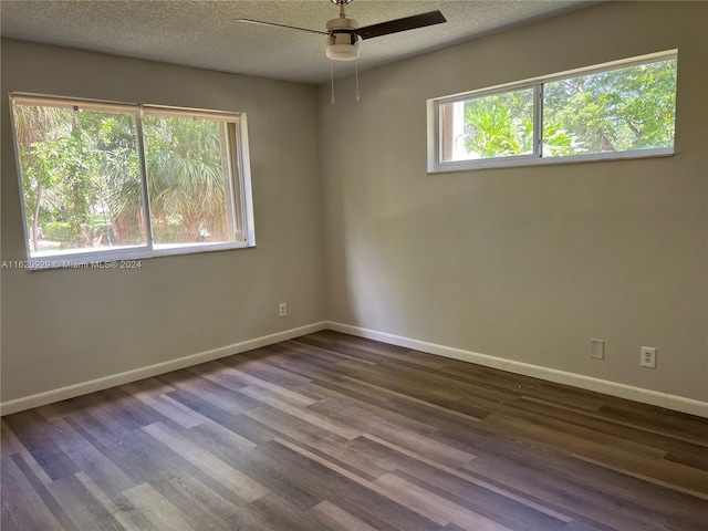 empty room with ceiling fan, a textured ceiling, baseboards, and wood finished floors