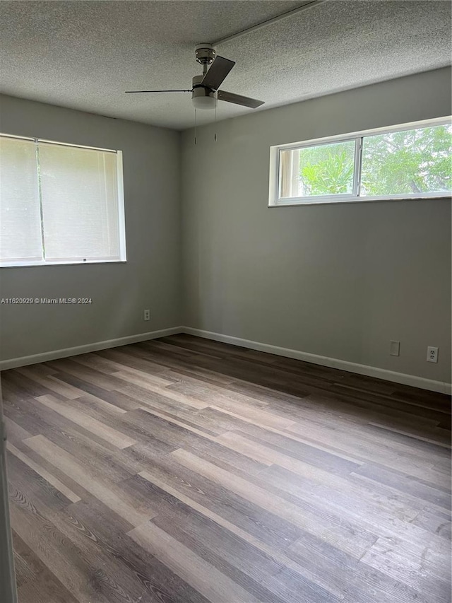 empty room with ceiling fan, a textured ceiling, and wood-type flooring