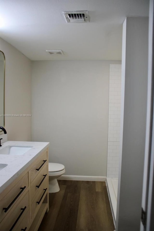 full bathroom with toilet, visible vents, a sink, and wood finished floors