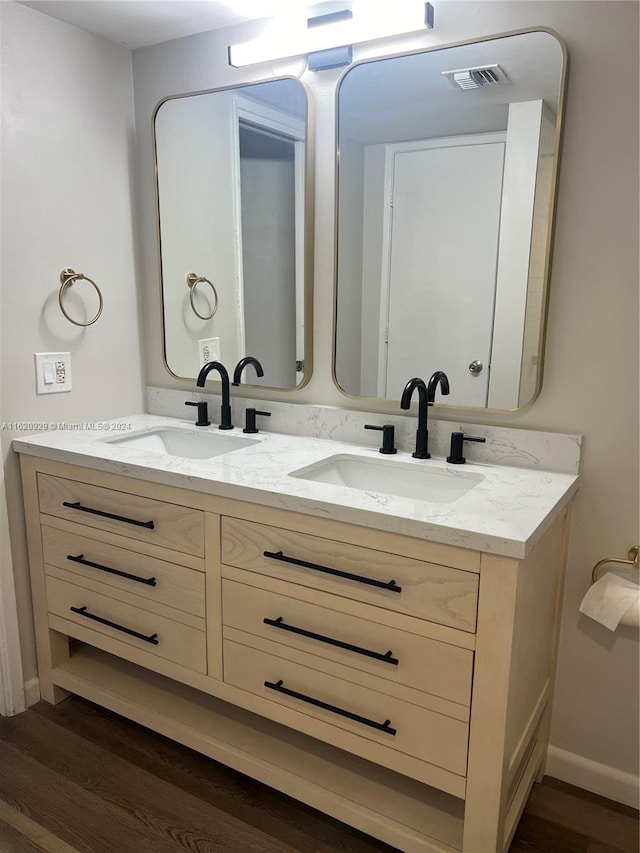 bathroom with wood-type flooring and double vanity