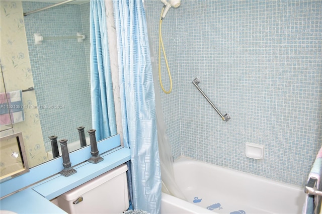 bathroom featuring shower / tub combo and toilet