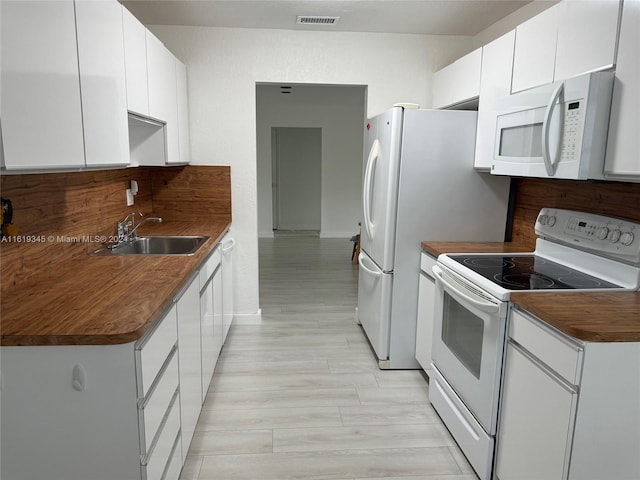 kitchen with sink, white cabinetry, and white appliances