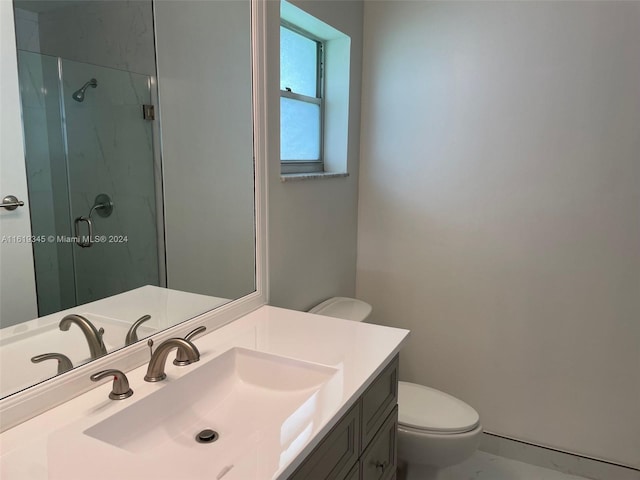 bathroom featuring a shower with shower door, toilet, and vanity