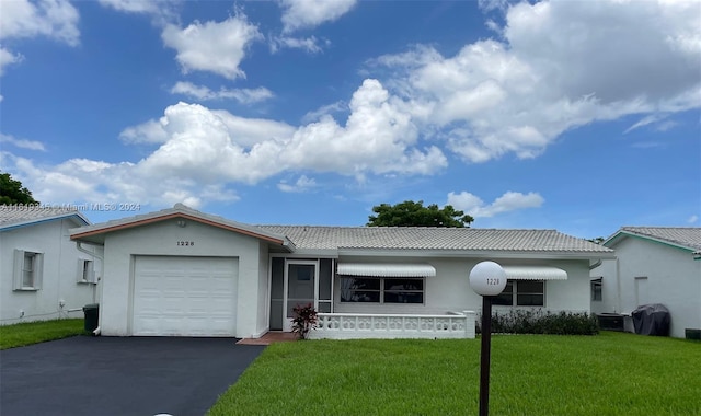 ranch-style home with a garage and a front yard