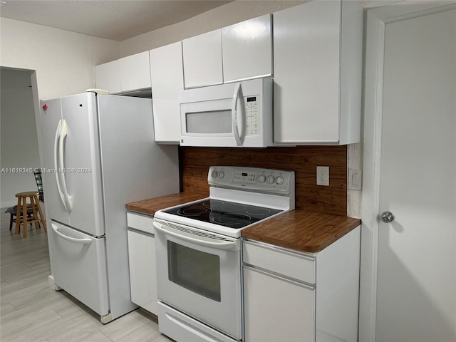 kitchen featuring backsplash, butcher block countertops, light hardwood / wood-style flooring, white appliances, and white cabinetry