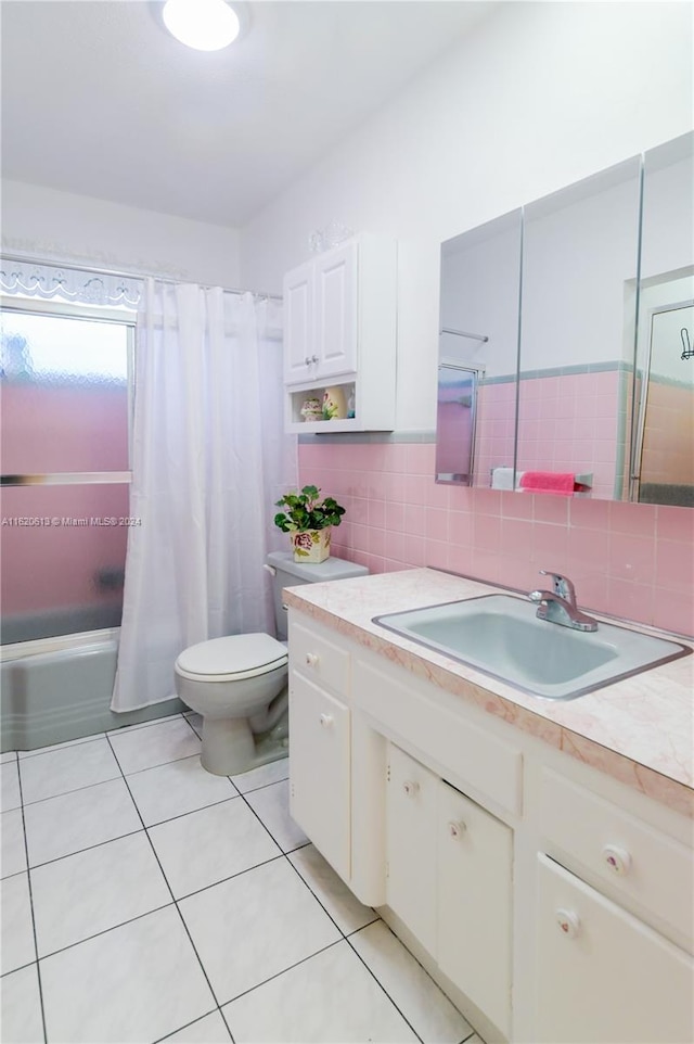 bathroom with tile walls, toilet, tasteful backsplash, and sink