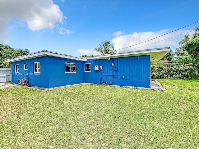 rear view of property with a lawn