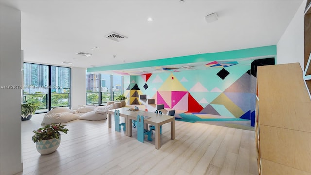 rec room with light hardwood / wood-style flooring and a wall of windows