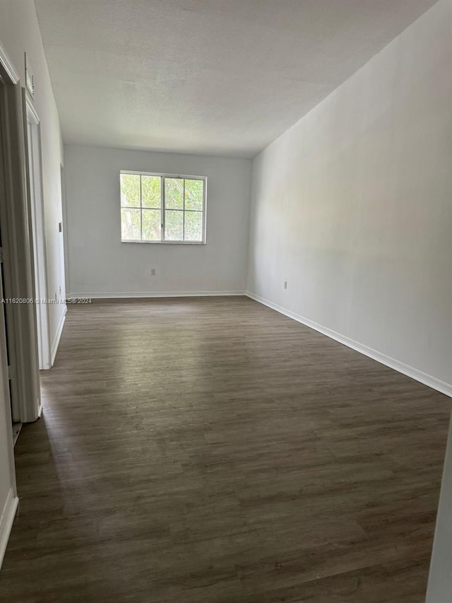 spare room with dark wood-type flooring