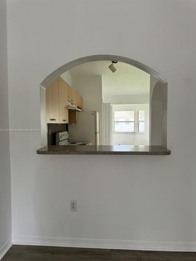 kitchen featuring dark hardwood / wood-style flooring, light brown cabinets, and white appliances