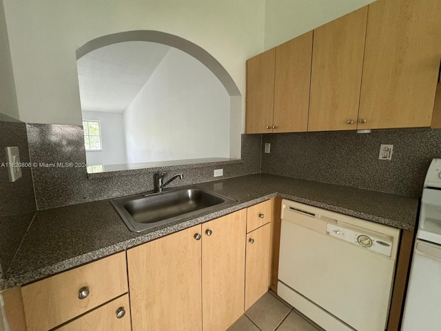 kitchen featuring sink, light tile patterned floors, white dishwasher, and tasteful backsplash