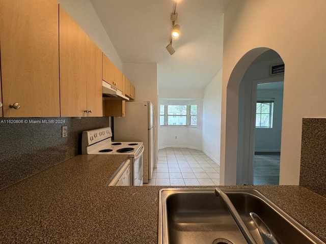 kitchen with light tile patterned floors, white electric stove, track lighting, decorative backsplash, and sink