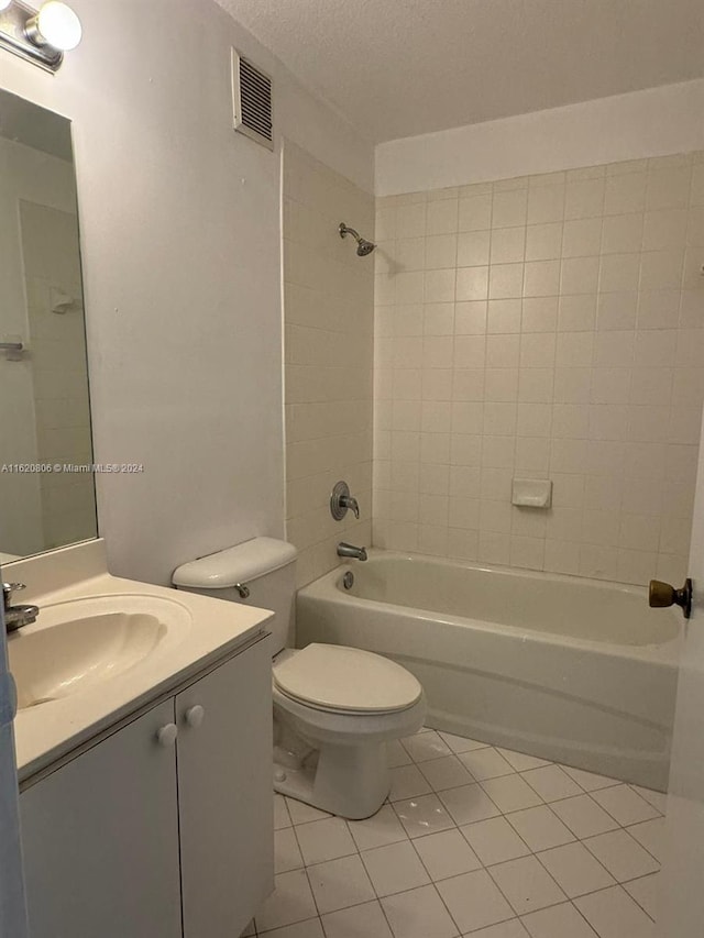 full bathroom with a textured ceiling, tile patterned floors, toilet, vanity, and tiled shower / bath combo