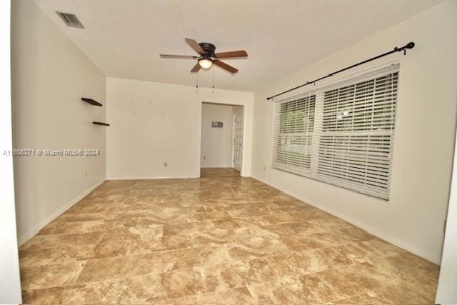 tiled spare room featuring ceiling fan