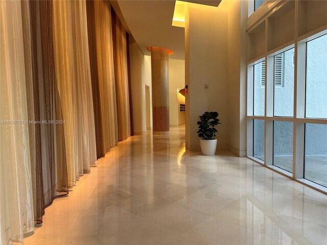 hall with light tile patterned flooring and a high ceiling