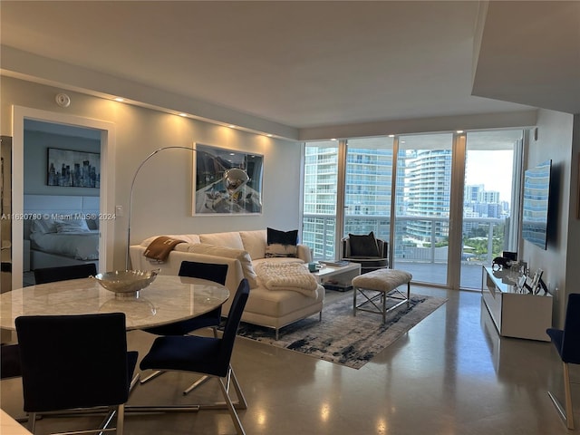 living room featuring finished concrete flooring and a wall of windows