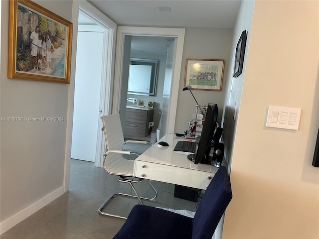 office with finished concrete flooring and baseboards