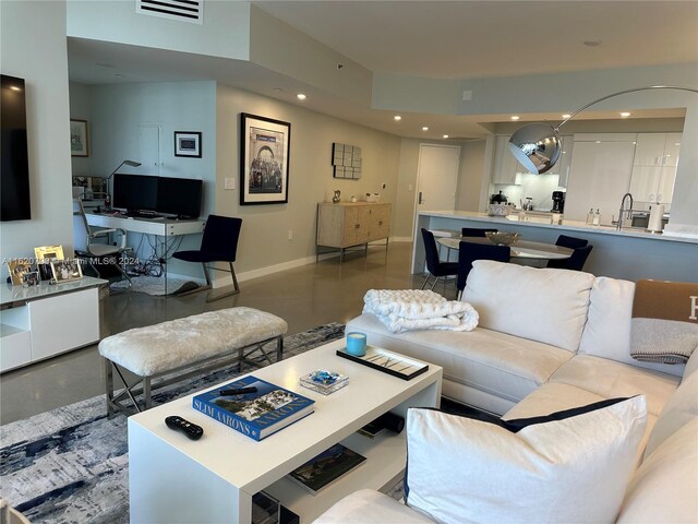 living room with concrete floors and sink