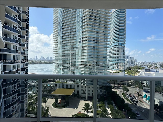 balcony with a water view and a view of city