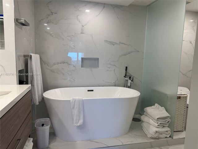 bathroom featuring tile patterned flooring, a bath, and vanity