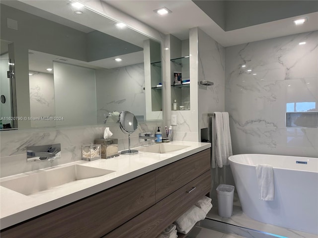 bathroom with marble finish floor, double vanity, a soaking tub, and a sink