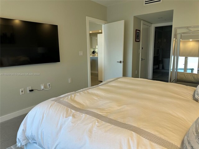 bedroom featuring ensuite bathroom and carpet floors