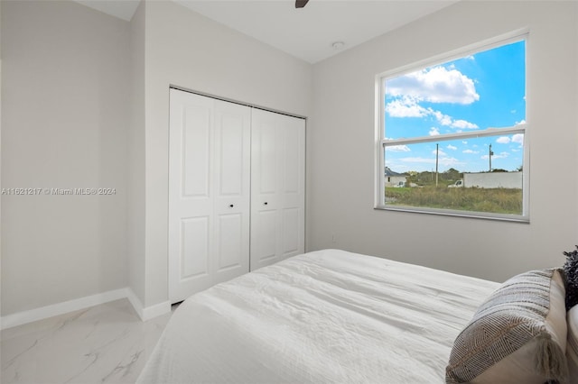 bedroom with a closet, multiple windows, and ceiling fan