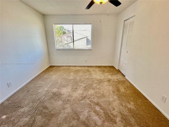 spare room featuring ceiling fan and light colored carpet