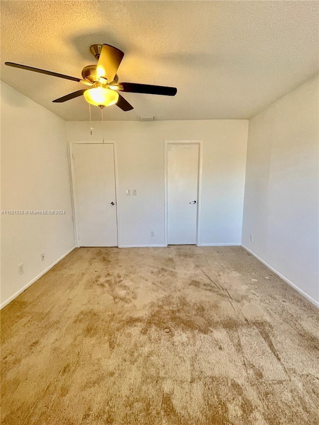 unfurnished bedroom featuring ceiling fan, a textured ceiling, and carpet floors