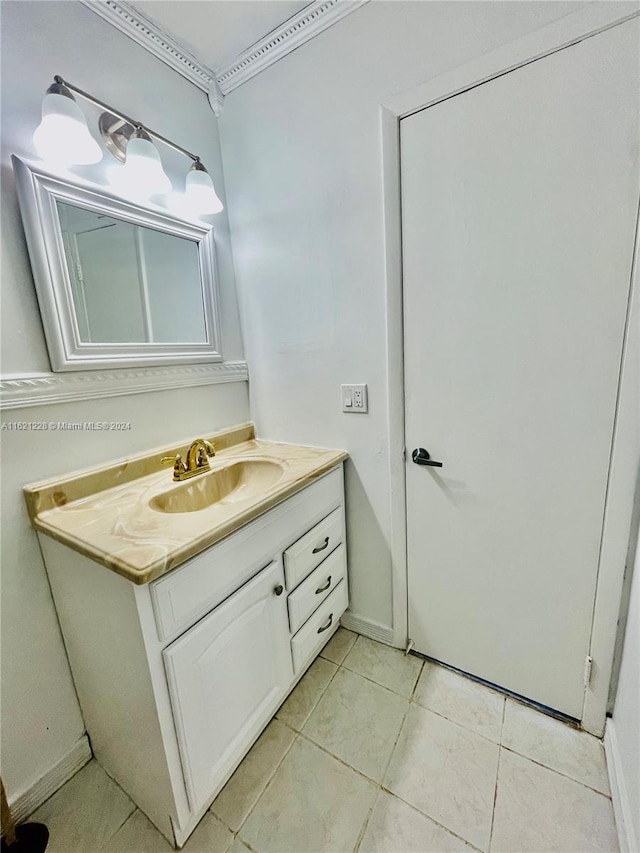 bathroom with tile patterned flooring, ornamental molding, and vanity