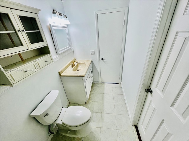 bathroom featuring toilet, vanity, and tile patterned flooring