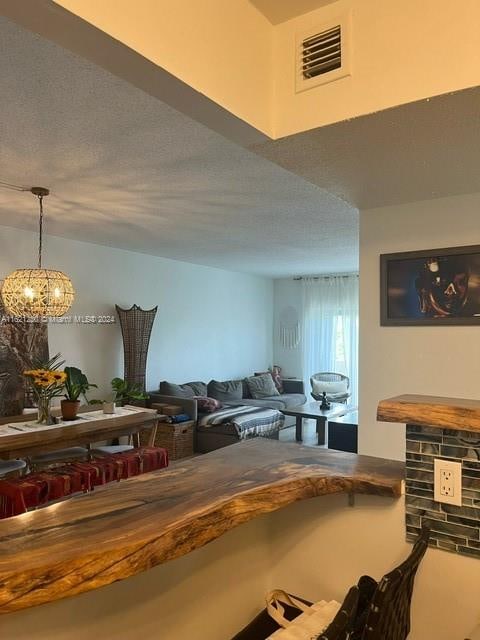 kitchen with a textured ceiling and a notable chandelier