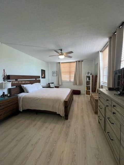 bedroom featuring a textured ceiling, ceiling fan, and hardwood / wood-style floors