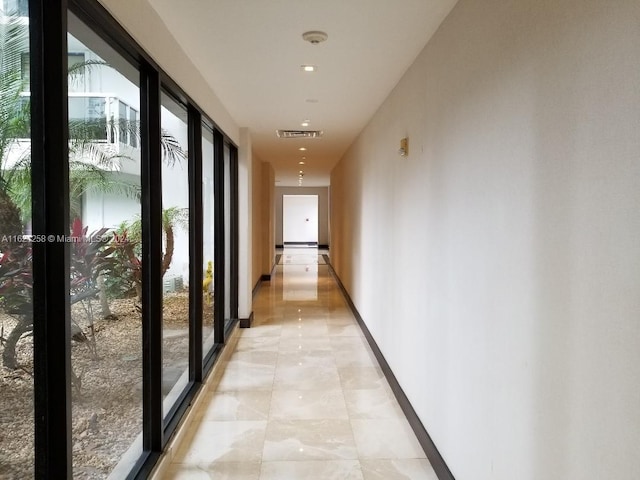 hallway featuring a healthy amount of sunlight and light tile patterned floors