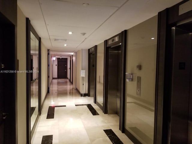 hall featuring elevator and light tile patterned floors