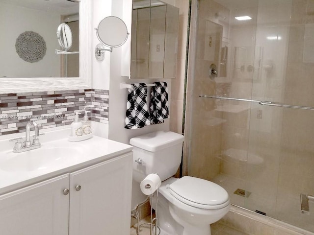 bathroom with vanity, toilet, backsplash, and walk in shower