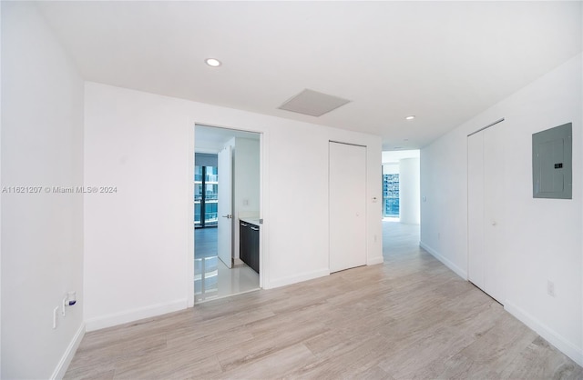 unfurnished room with electric panel and light wood-type flooring